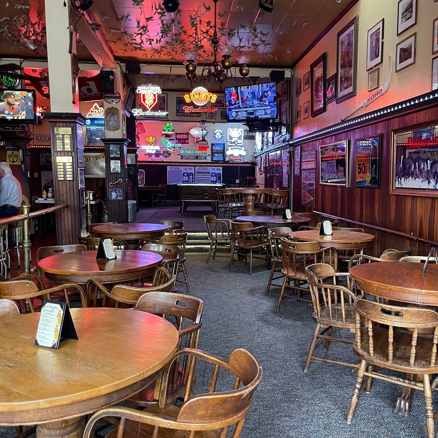 The room at Nave's — neon signs, TVs and tables